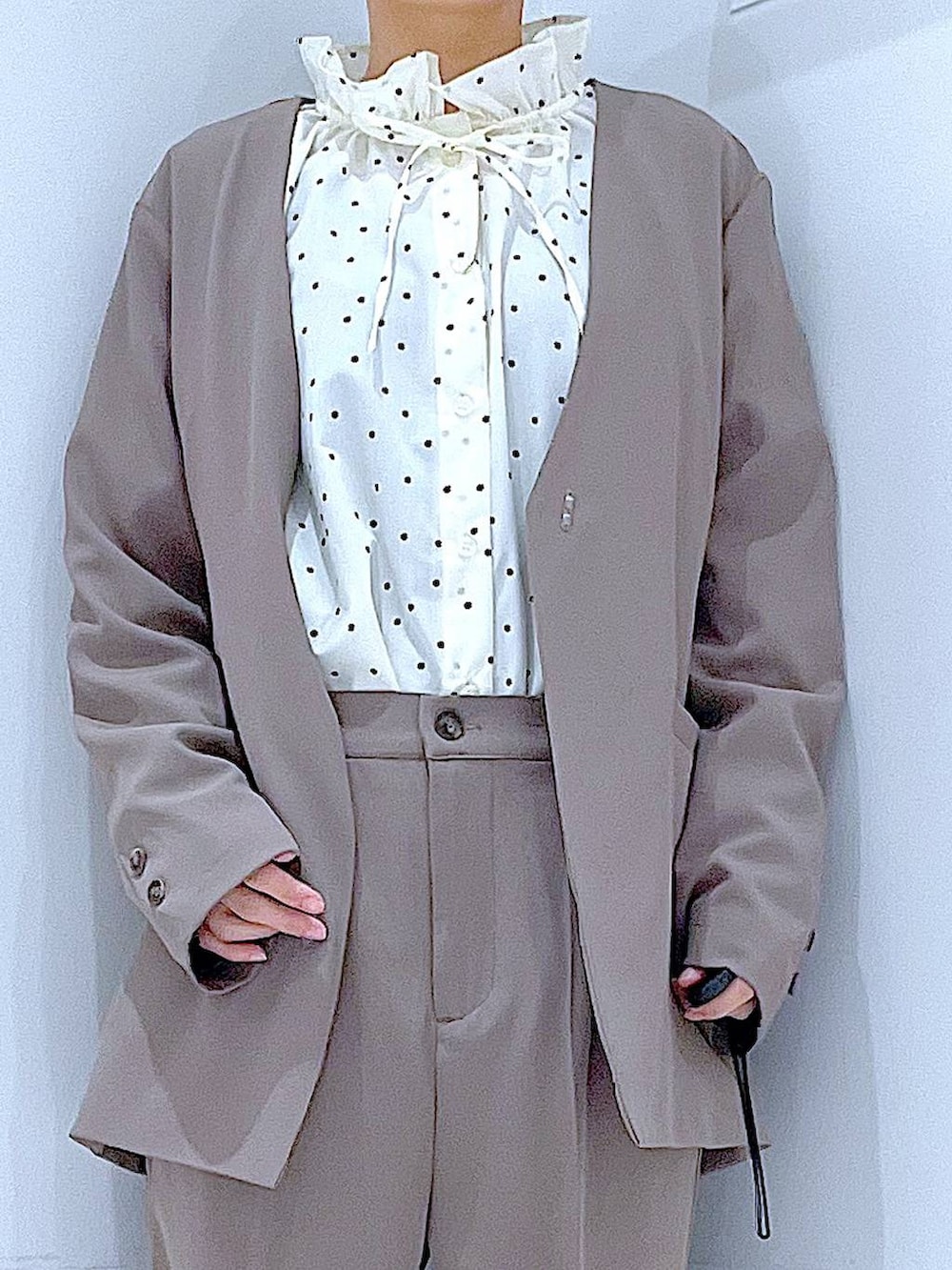 ブラック系のブーツ、グレー系のトートバッグ、ブラウン系のノーカラージャケットを着用したレディースの冬コーディネートの7枚目の写真