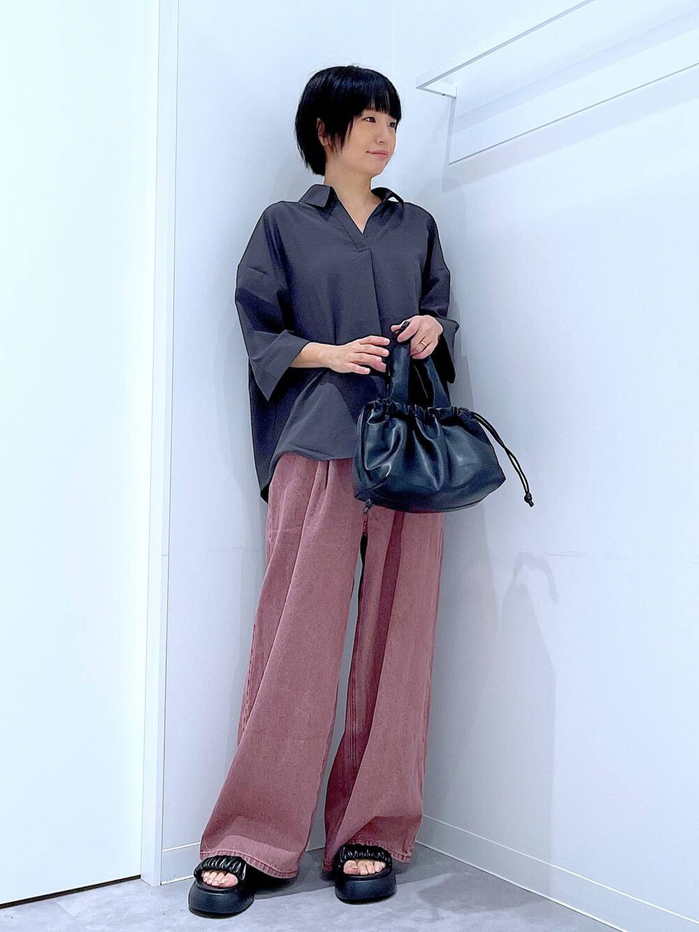 ブラック系のサンダル、ブラック系のショルダーバッグ、グレー系のシャツ/ブラウスを着用したレディースの夏コーディネートの2枚目の写真