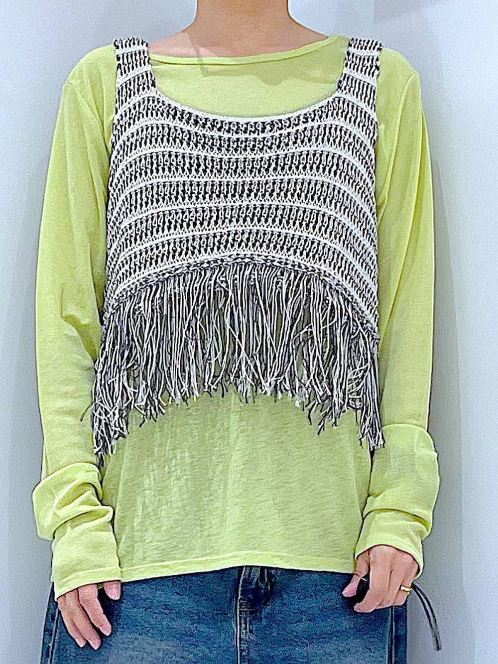 ブルー系のデニムパンツ、グリーン系のTシャツ/カットソー、ブラック系のショルダーバッグを着用したレディースの春コーディネートの7枚目の写真