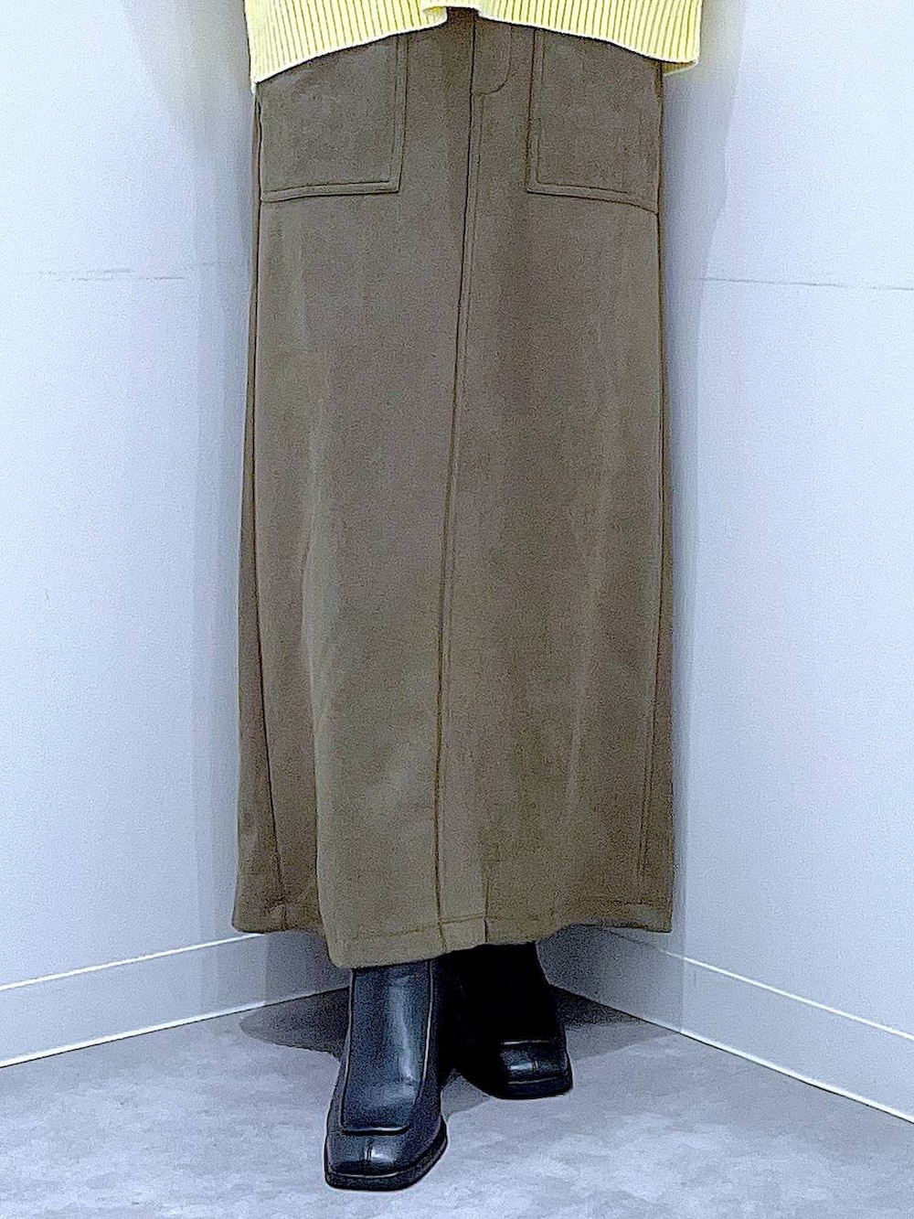 ブラック系のブーツ、グリーン系のスカート、ホワイト系のトートバッグを着用したレディースの冬コーディネートの8枚目の写真