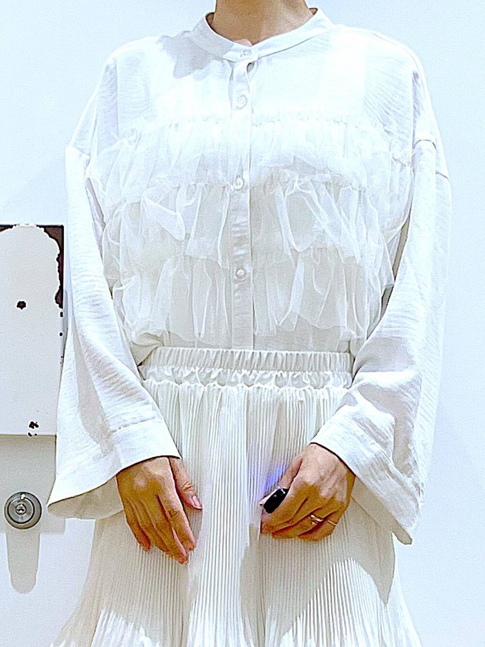 ベージュ系のスカート、シルバー系のパンプス、ホワイト系のシャツ/ブラウスを着用したレディースの秋コーディネートの7枚目の写真