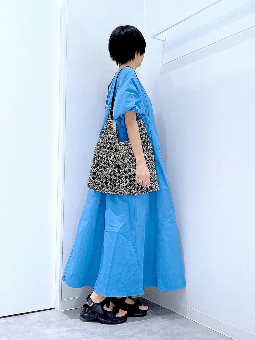 ブラック系のトートバッグ、ブラック系のサンダル、ブルー系のワンピースを着用したレディースの夏コーディネートの4枚目の写真