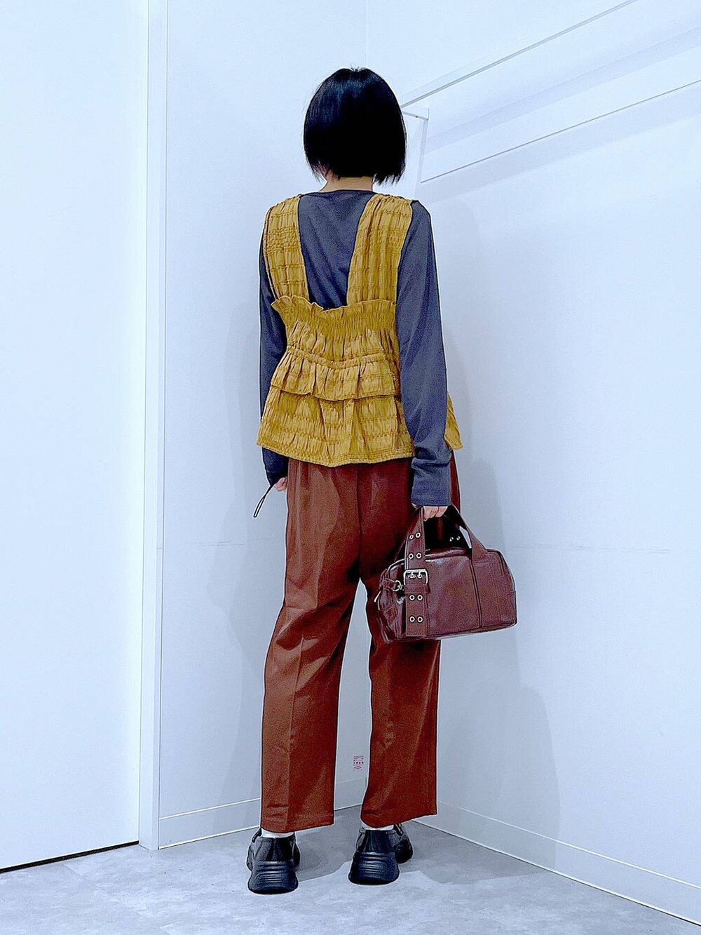 グレー系のTシャツ/カットソー、ブラック系のローファー、ブラック系のショルダーバッグを着用したレディースの秋コーディネートの5枚目の写真