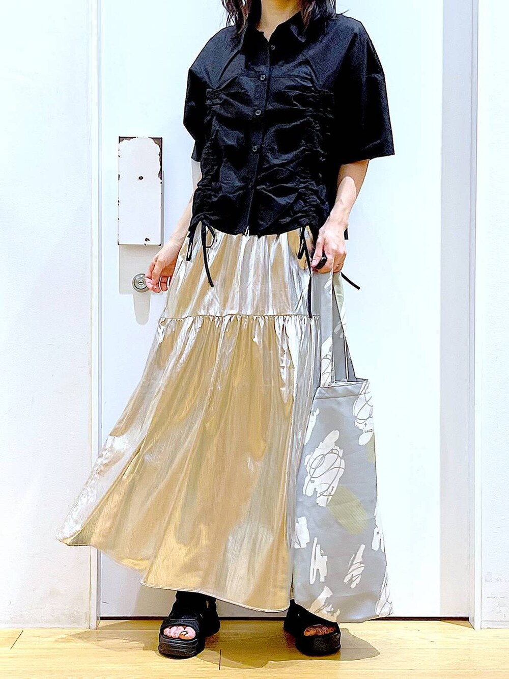 ブラック系のサンダル、グレー系のシャツ/ブラウス、グレー系のトートバッグを着用したレディースの夏コーディネートの6枚目の写真