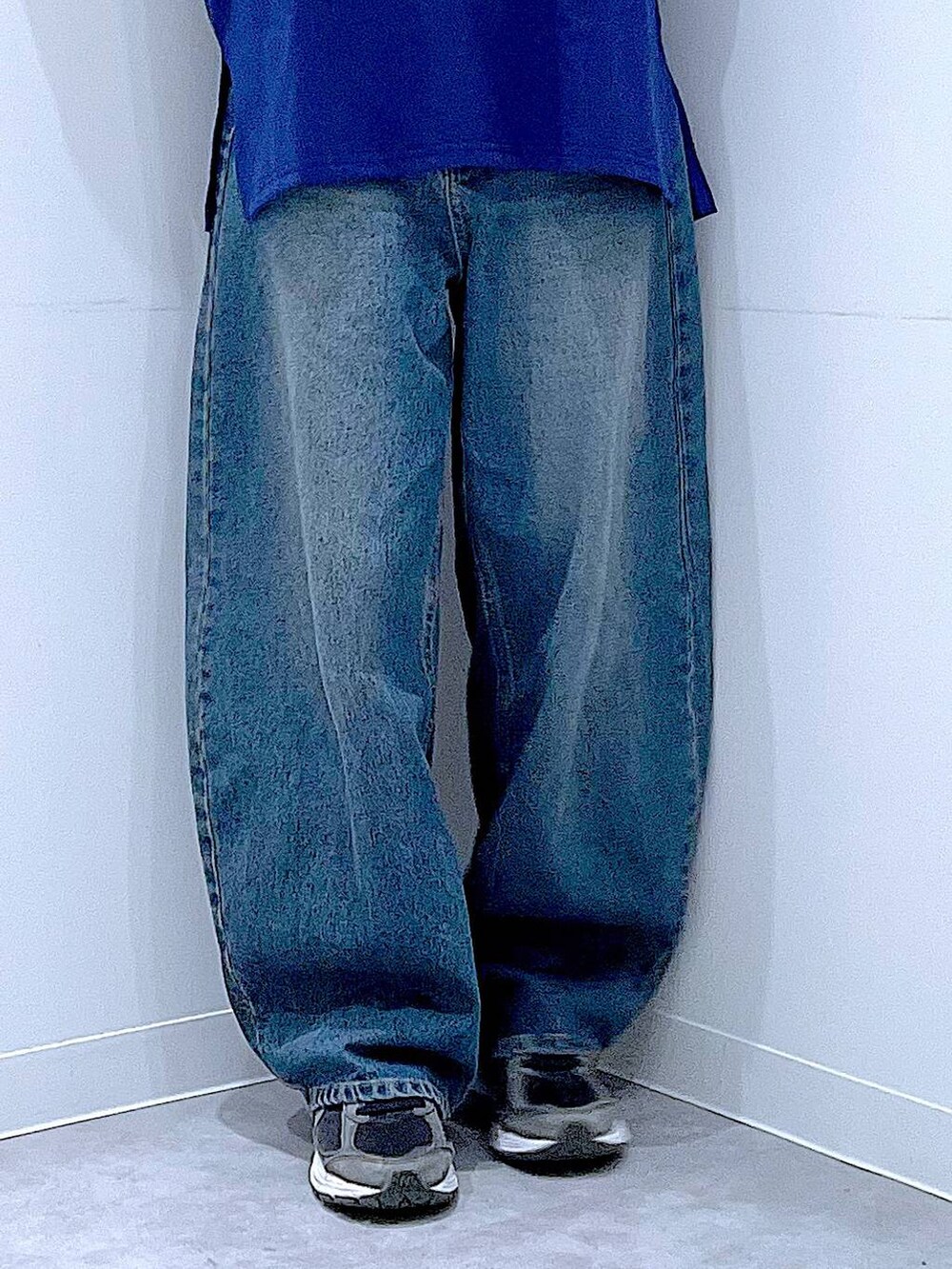 ブルー系のデニムパンツ、ホワイト系のショルダーバッグ、ブルー系のポロシャツを着用したレディースの冬コーディネートの8枚目の写真