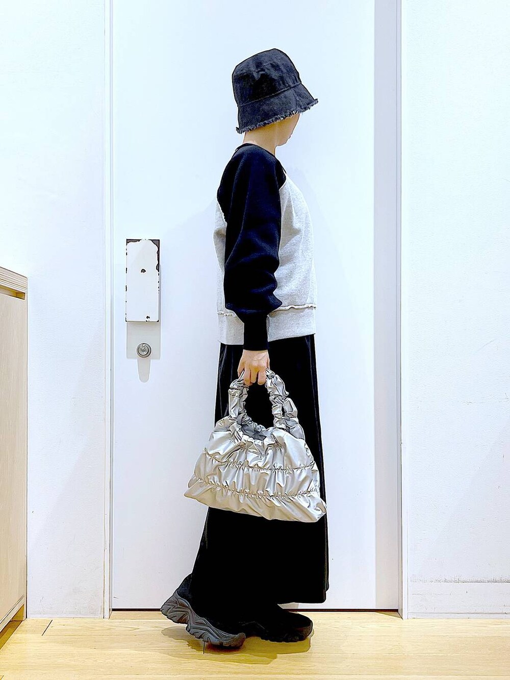 ブラック系のブーツ、シルバー系のショルダーバッグ、ブラック系のニット/セーターを着用したレディースの冬コーディネートの4枚目の写真