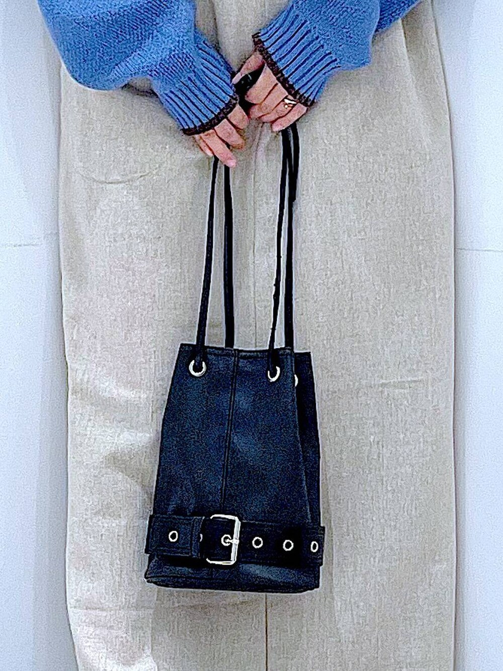 ブラック系のブーツ、ブラック系のハンドバッグ、ブルー系のニット/セーターを着用したレディースの秋コーディネートの9枚目の写真