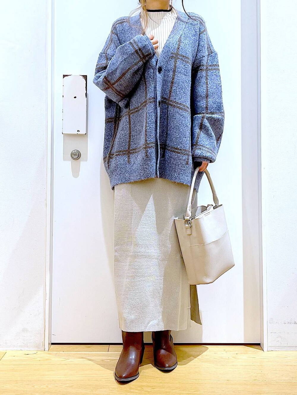 ブルー系のカーディガン/ボレロ、グレー系のショルダーバッグ、グレー系のスカートを着用したレディースの冬コーディネートの6枚目の写真
