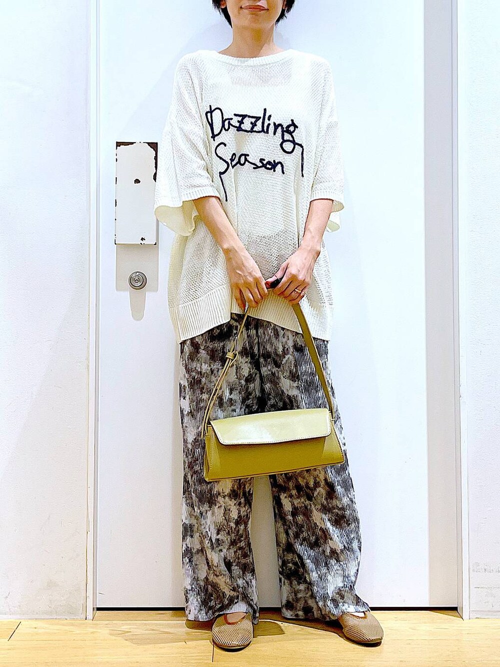 ベージュ系のパンプス、イエロー系のショルダーバッグ、グレー系のその他パンツを着用したレディースの春コーディネートの6枚目の写真