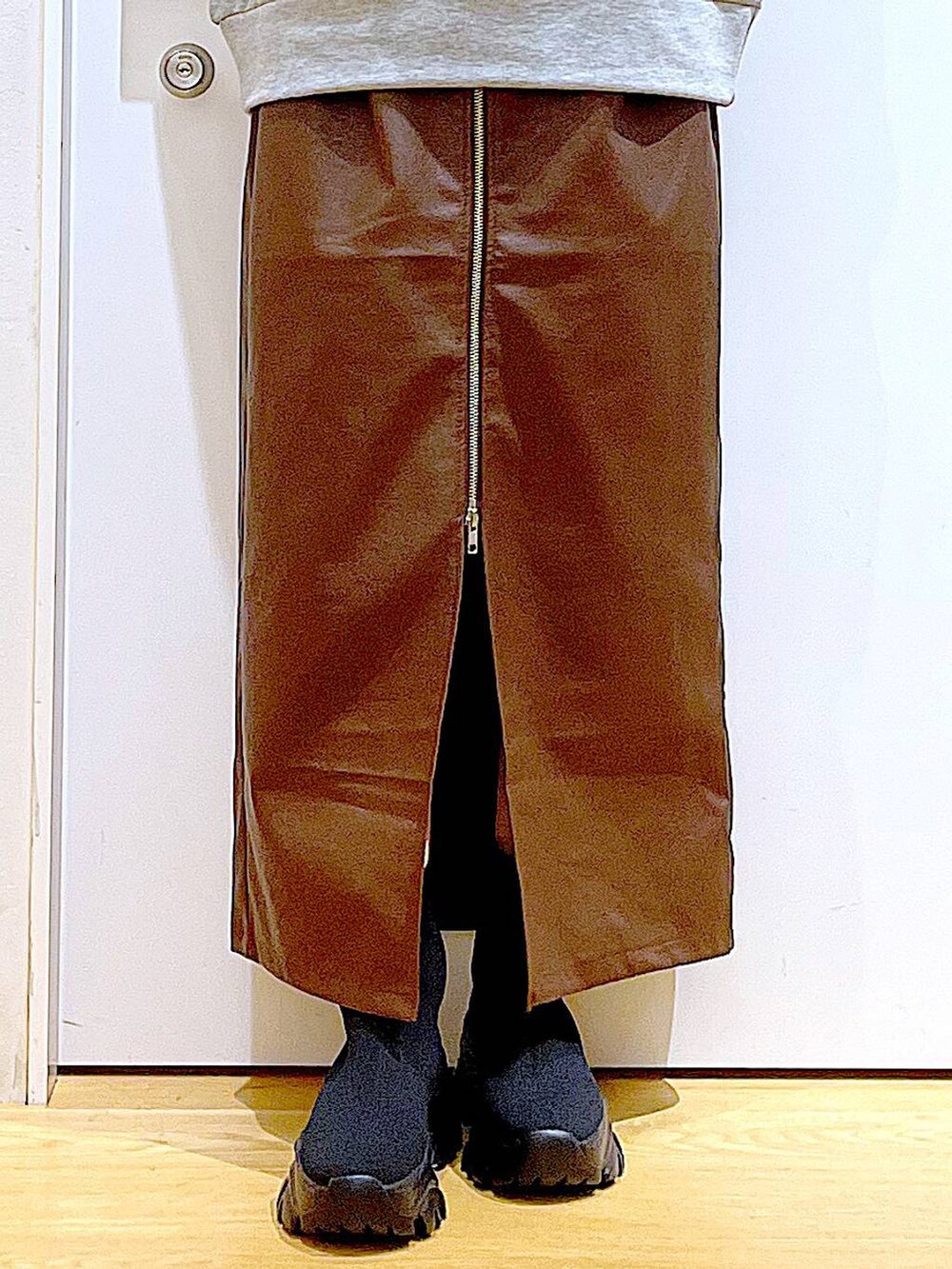 ブラウン系のスカート、ブラック系のショルダーバッグ、ブラック系のブーツを着用したレディースの冬コーディネートの8枚目の写真