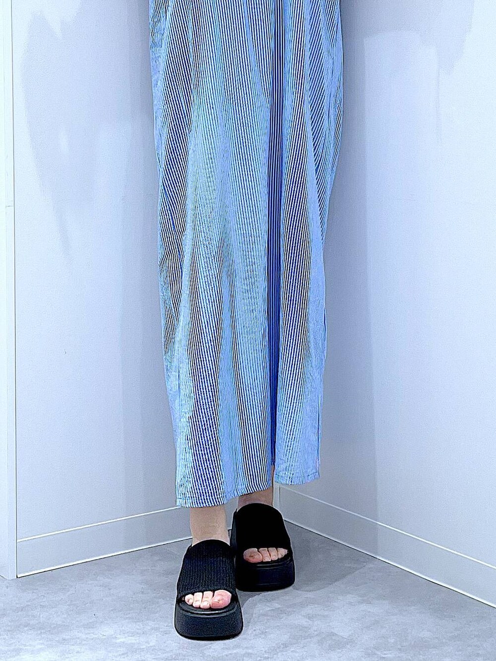 ブルー系のショルダーバッグ、ブラック系のサンダル、ホワイト系のTシャツ/カットソーを着用したレディースの夏コーディネートの8枚目の写真