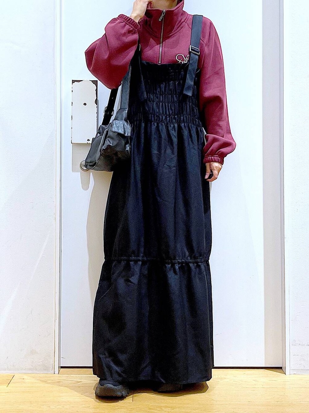 ブラック系のブーツ、ブラック系のショルダーバッグ、ブラック系のワンピースを着用したレディースの秋コーディネートの6枚目の写真