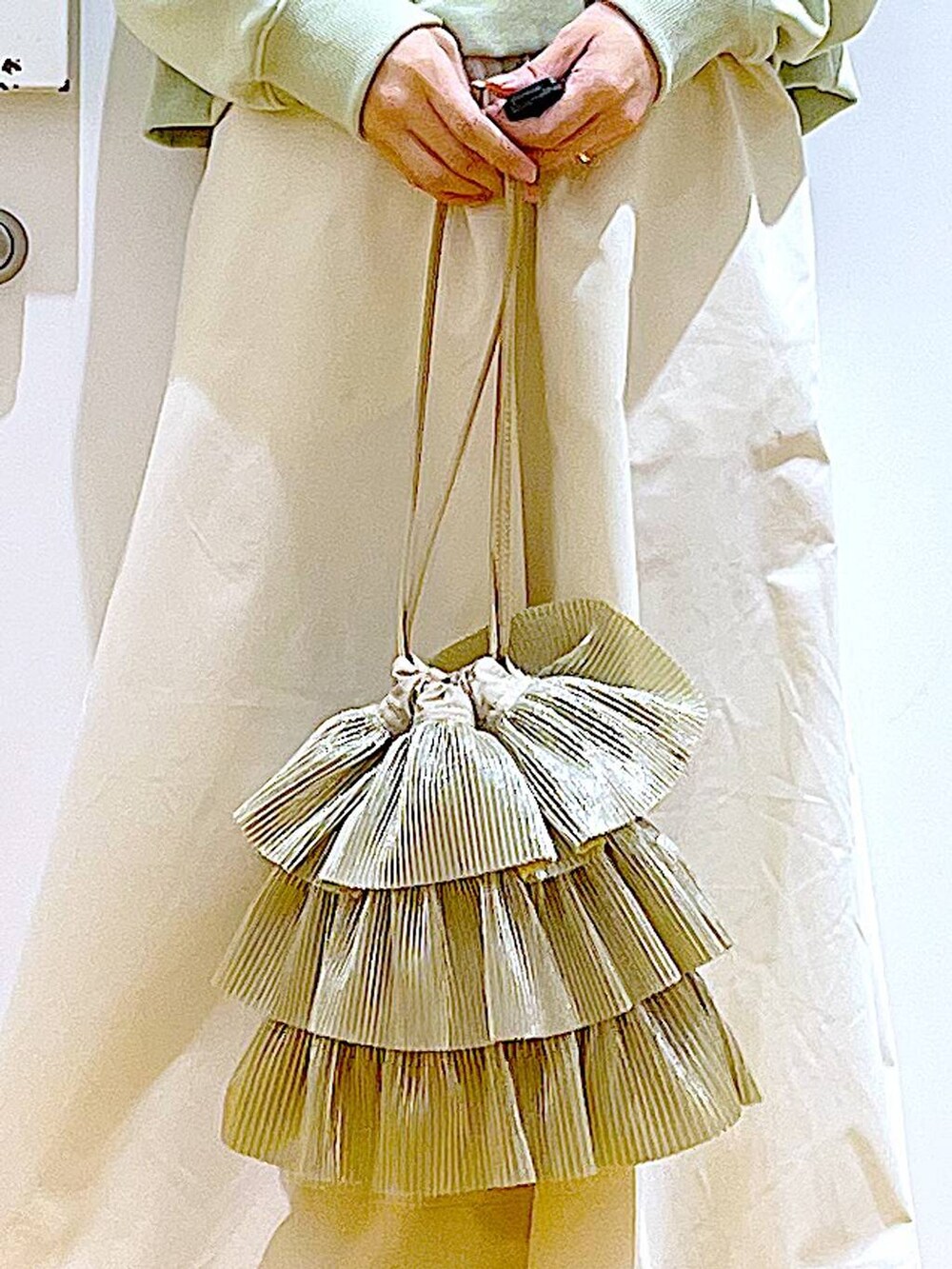 ホワイト系のパンプス、ベージュ系のショルダーバッグ、グリーン系のスウェットを着用したレディースの春コーディネートの9枚目の写真