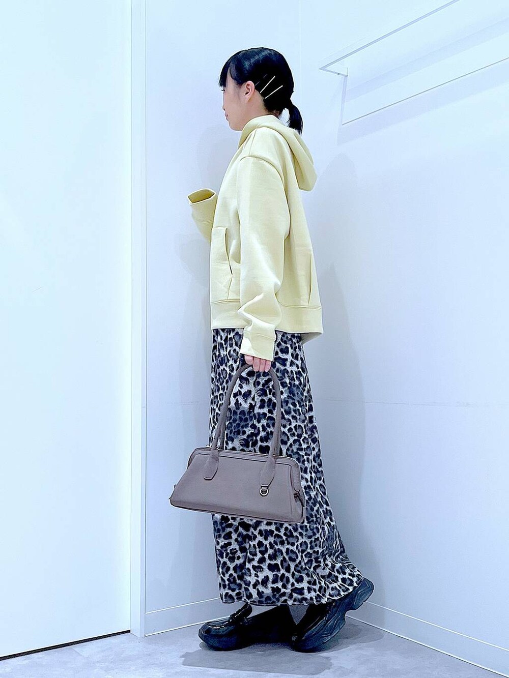 ブラック系のローファー、グレー系のスカート、イエロー系のパーカーを着用したレディースの秋コーディネートの3枚目の写真