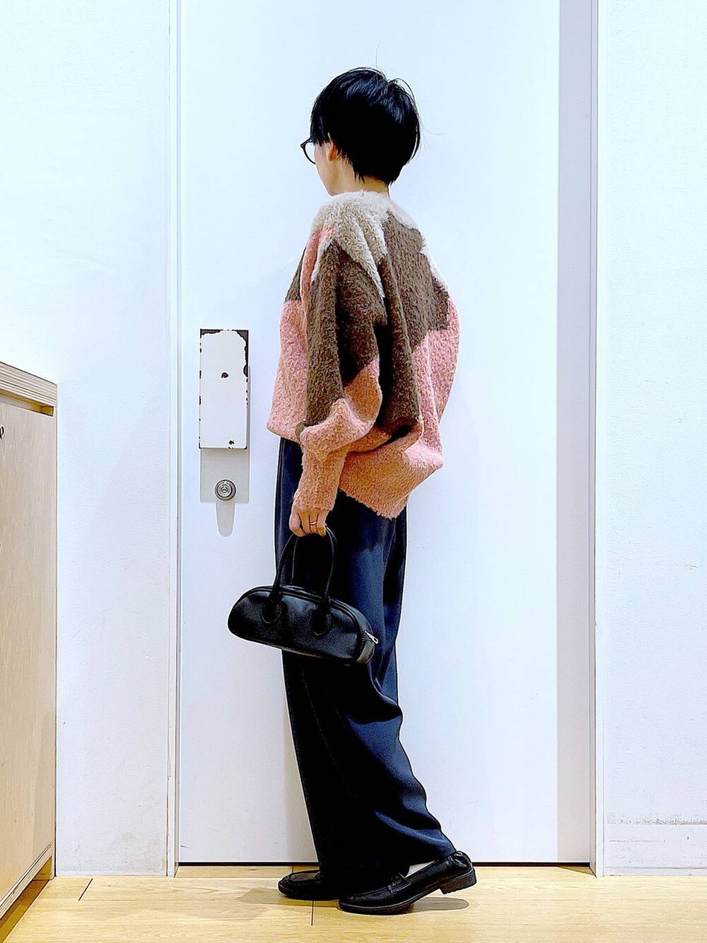 ブラック系のローファー、ピンク系のニット/セーター、ブラック系のボストンバッグを着用したレディースの冬コーディネートの3枚目の写真