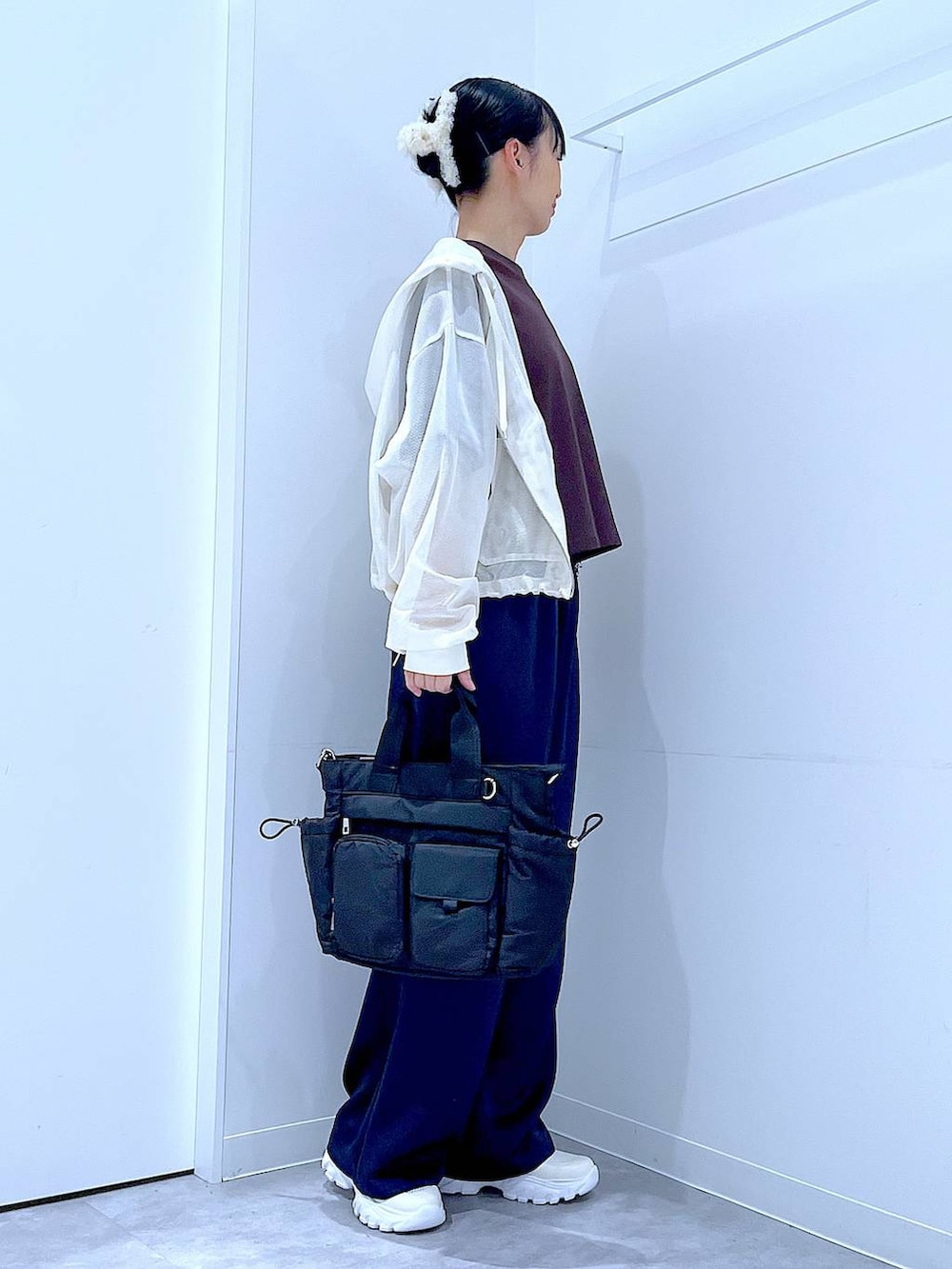 ブラック系のトートバッグ、ブルー系のその他パンツ、ホワイト系のスニーカーを着用したレディースの春コーディネートの4枚目の写真