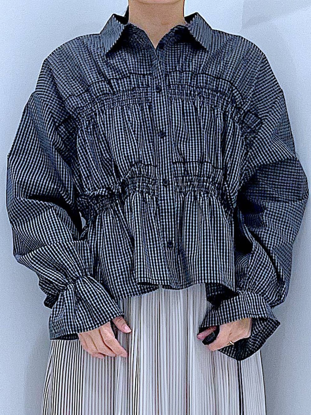グレー系のハンドバッグ、ブラック系のシャツ/ブラウス、ベージュ系のスカートを着用したレディースの春コーディネートの7枚目の写真