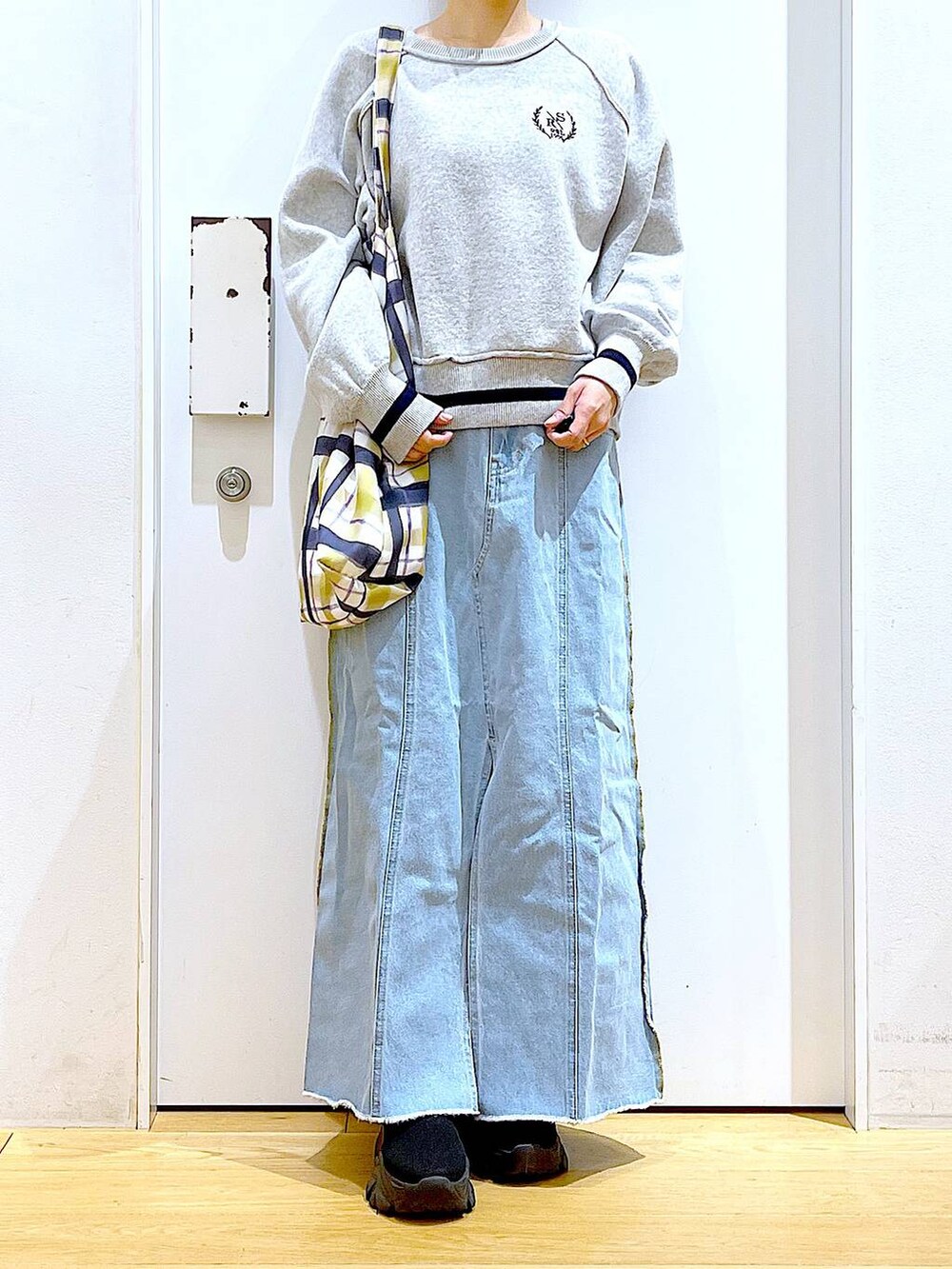 ブルー系のデニムスカート、その他のトートバッグ、ブラック系のブーツを着用したレディースの冬コーディネートの6枚目の写真