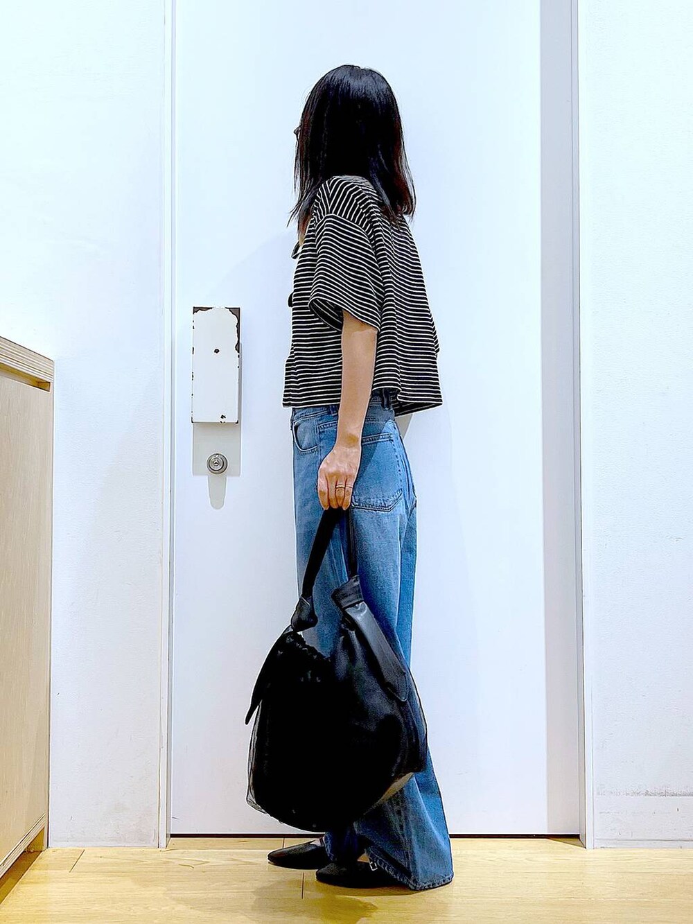 ブラック系のトートバッグ、ブルー系のデニムパンツ、その他のカーディガン/ボレロを着用したレディースの秋コーディネートの3枚目の写真