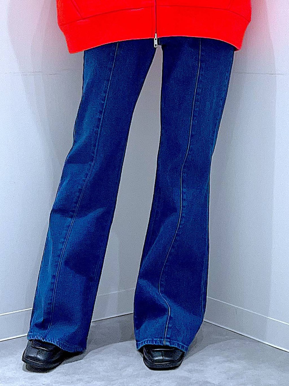 レッド系のパーカー、ブラック系のブーツ、グレー系のニット/セーターを着用したレディースの冬コーディネートの8枚目の写真