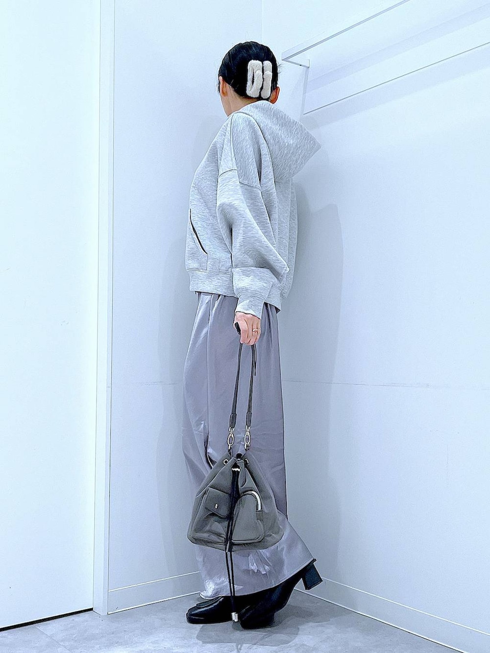 ブラック系のブーツ、グレー系のスカート、グレー系のパーカーを着用したレディースの春コーディネートの3枚目の写真