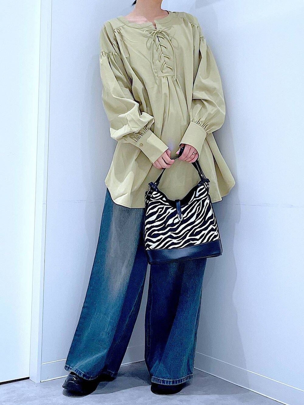 ブラック系のローファー、その他のショルダーバッグ、ブルー系のデニムパンツを着用したレディースの秋コーディネートの5枚目の写真