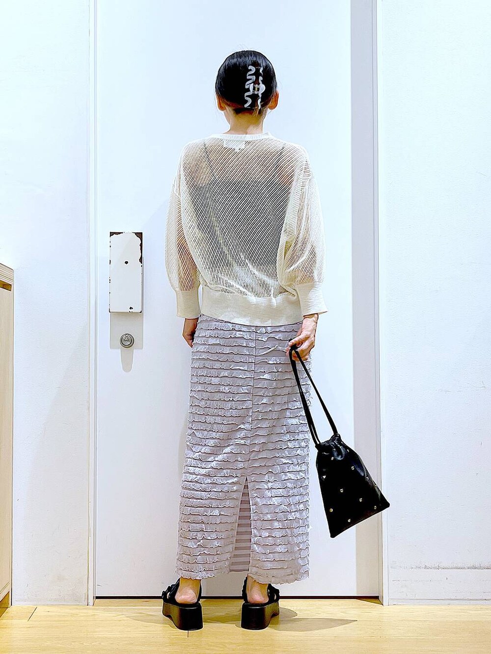 ブラック系のサンダル、ブラック系のショルダーバッグ、ホワイト系のカーディガン/ボレロを着用したレディースの夏コーディネートの5枚目の写真