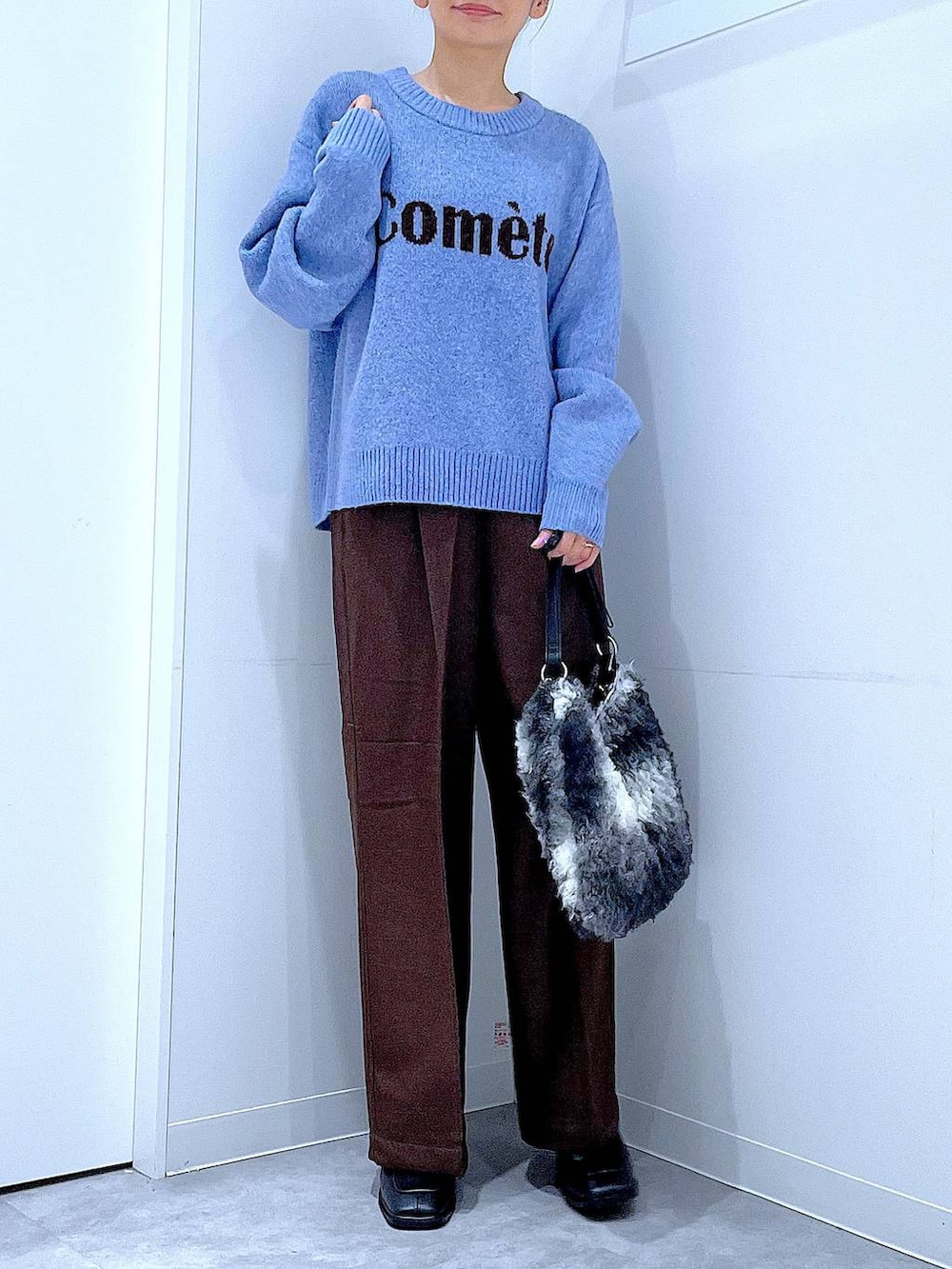 ブラック系のブーツ、ブラウン系のスラックス、ブラック系のショルダーバッグを着用したレディースの冬コーディネートの6枚目の写真