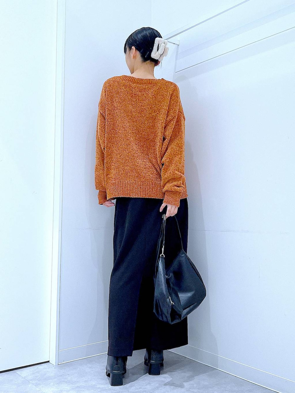 ブラック系のスカート、ブラック系のブーツ、ブラック系のショルダーバッグを着用したレディースの冬コーディネートの5枚目の写真