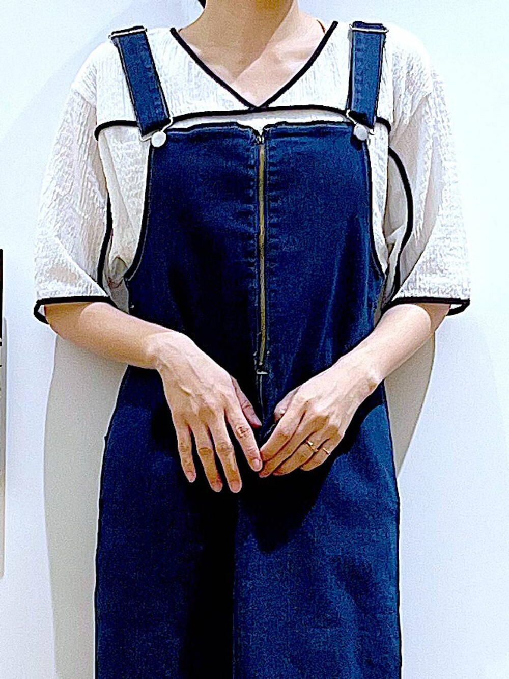 ブルー系のジャンパースカート、ブラウン系のショルダーバッグ、ブラック系のサンダルを着用したレディースの夏コーディネートの7枚目の写真