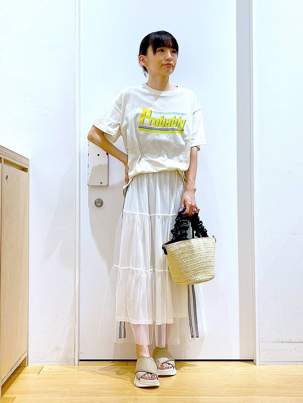 ベージュ系のサンダル、ベージュ系のTシャツ/カットソー、ホワイト系のショルダーバッグを着用したレディースの夏コーディネートの2枚目の写真