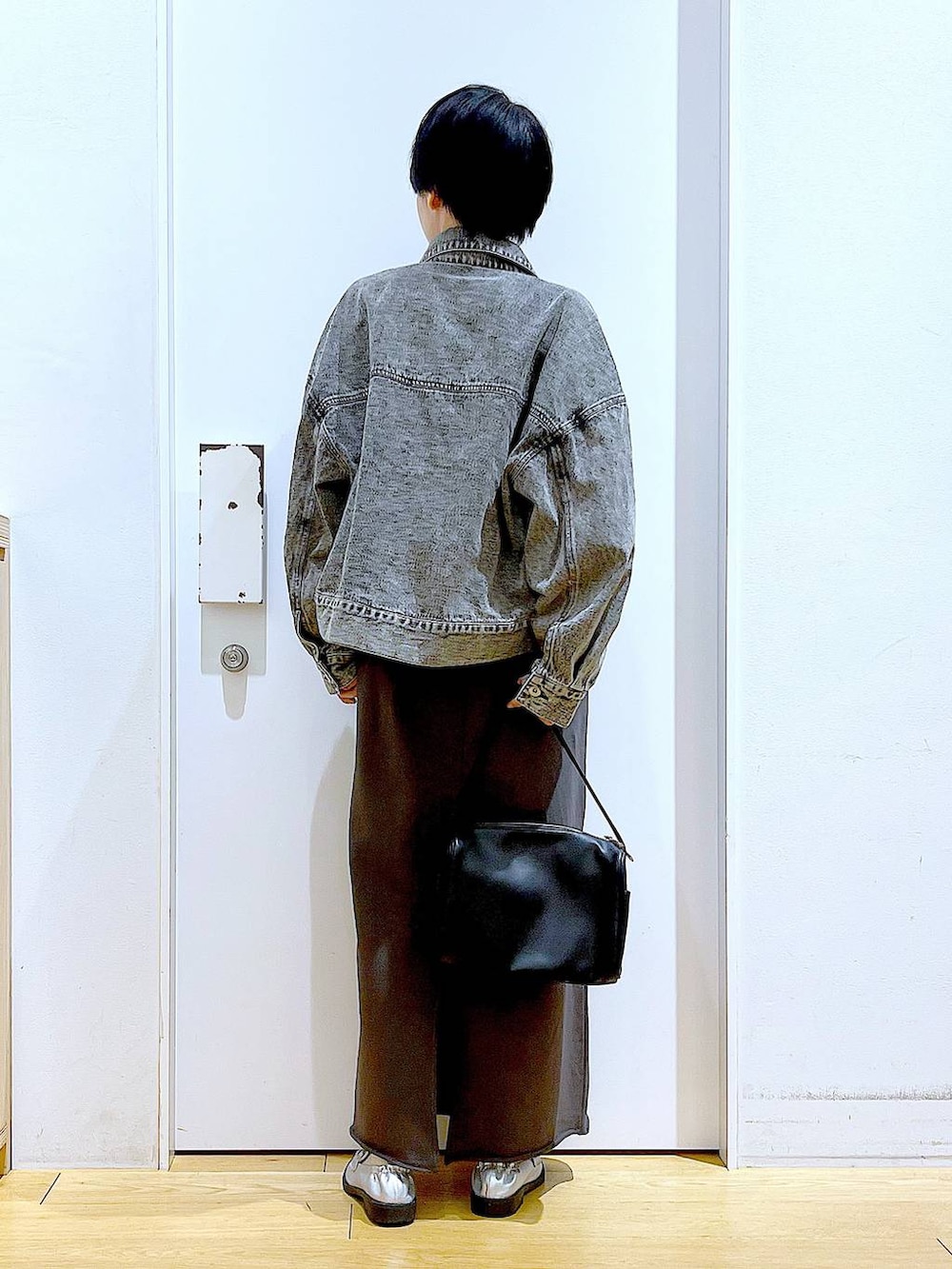 ブラック系のショルダーバッグ、シルバー系のローファー、ブラック系のデニムジャケットを着用したレディースの春コーディネートの5枚目の写真