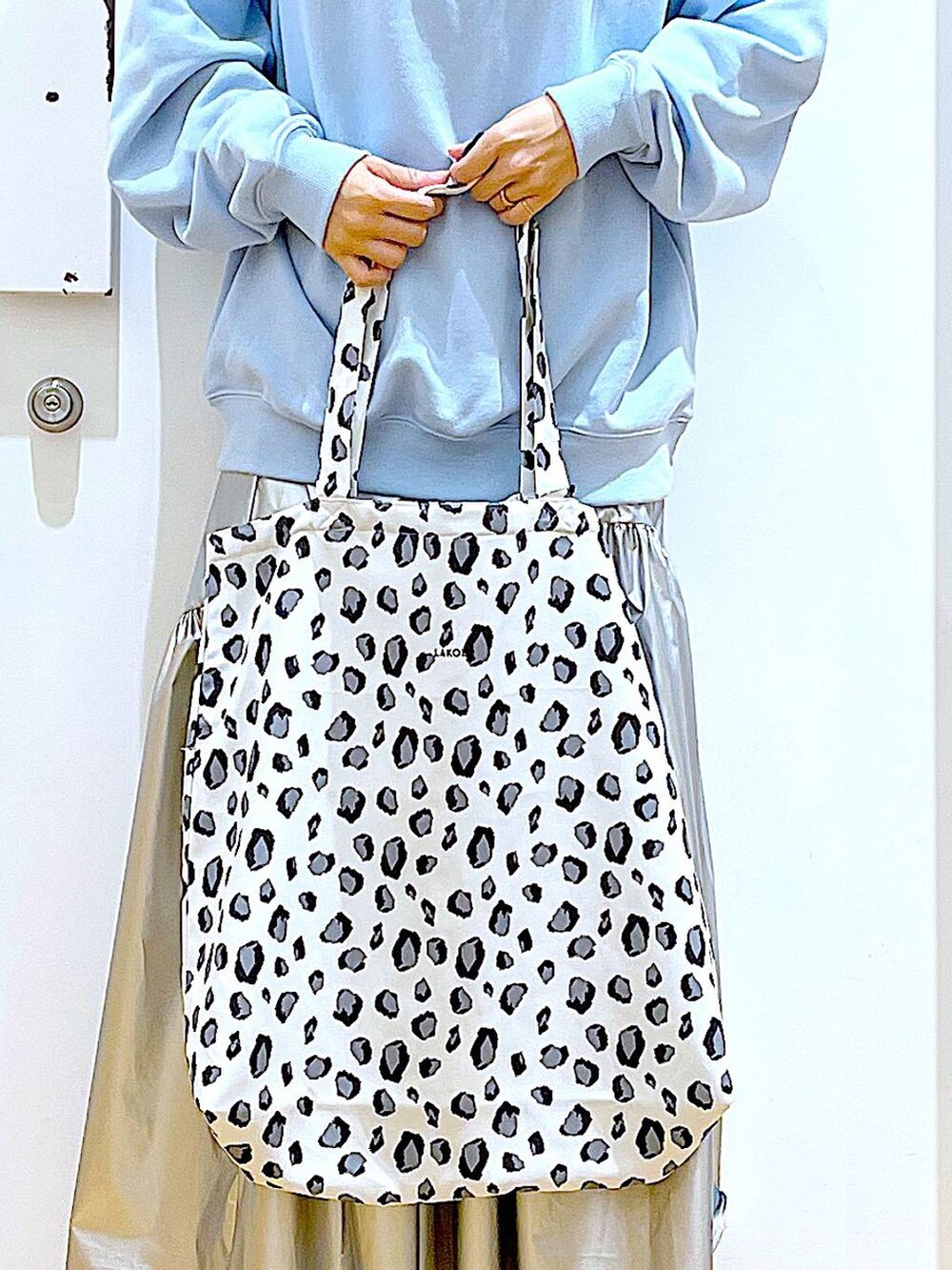 ブルー系のスウェット、シルバー系のスカート、ベージュ系のブーツを着用したレディースの春コーディネートの9枚目の写真