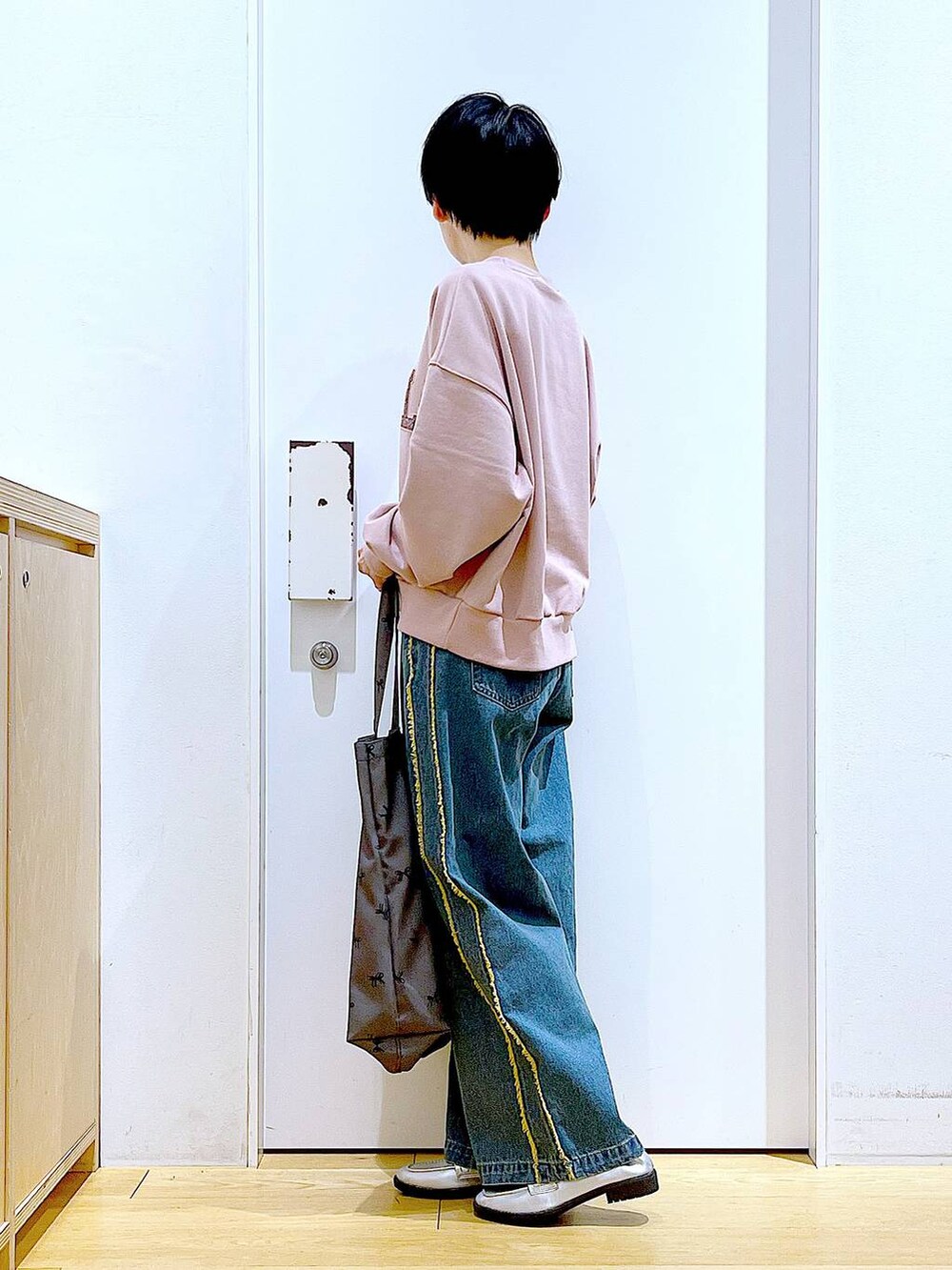 シルバー系のローファー、ブルー系のデニムパンツ、その他のトートバッグを着用したレディースの春コーディネートの3枚目の写真