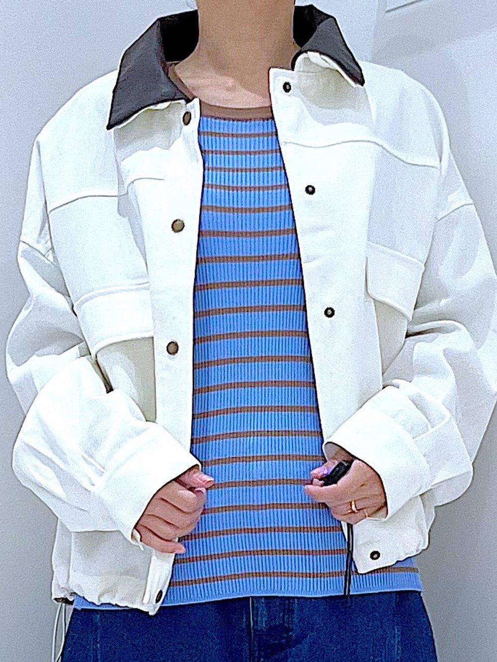 ブルー系のニット/セーター、ブルー系のデニムパンツ、ベージュ系のブルゾンを着用したレディースの冬コーディネートの7枚目の写真