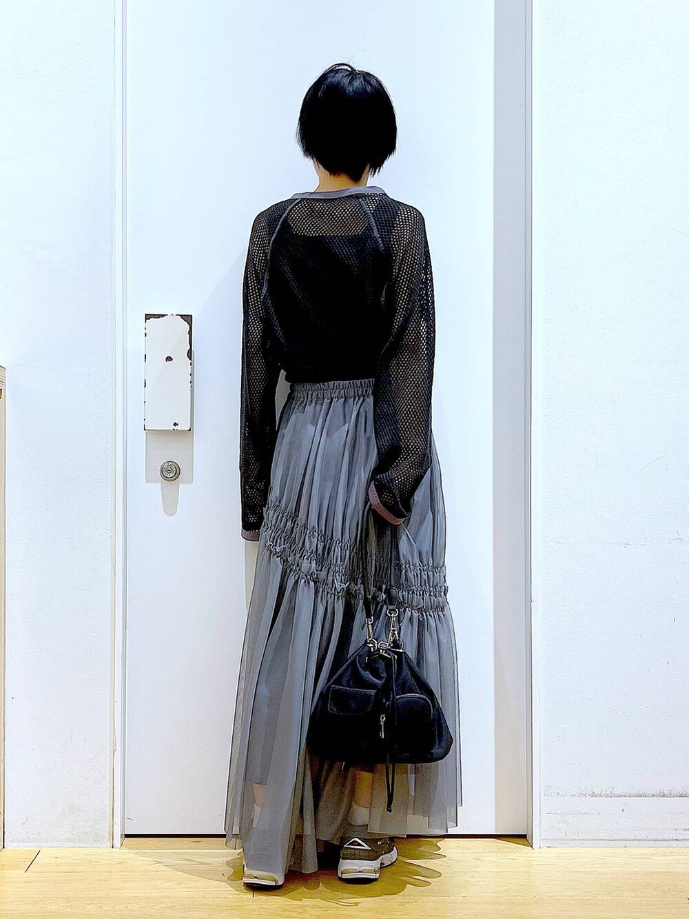 ブラック系のTシャツ/カットソー、グレー系のスカートを着用したレディースの春コーディネートの5枚目の写真