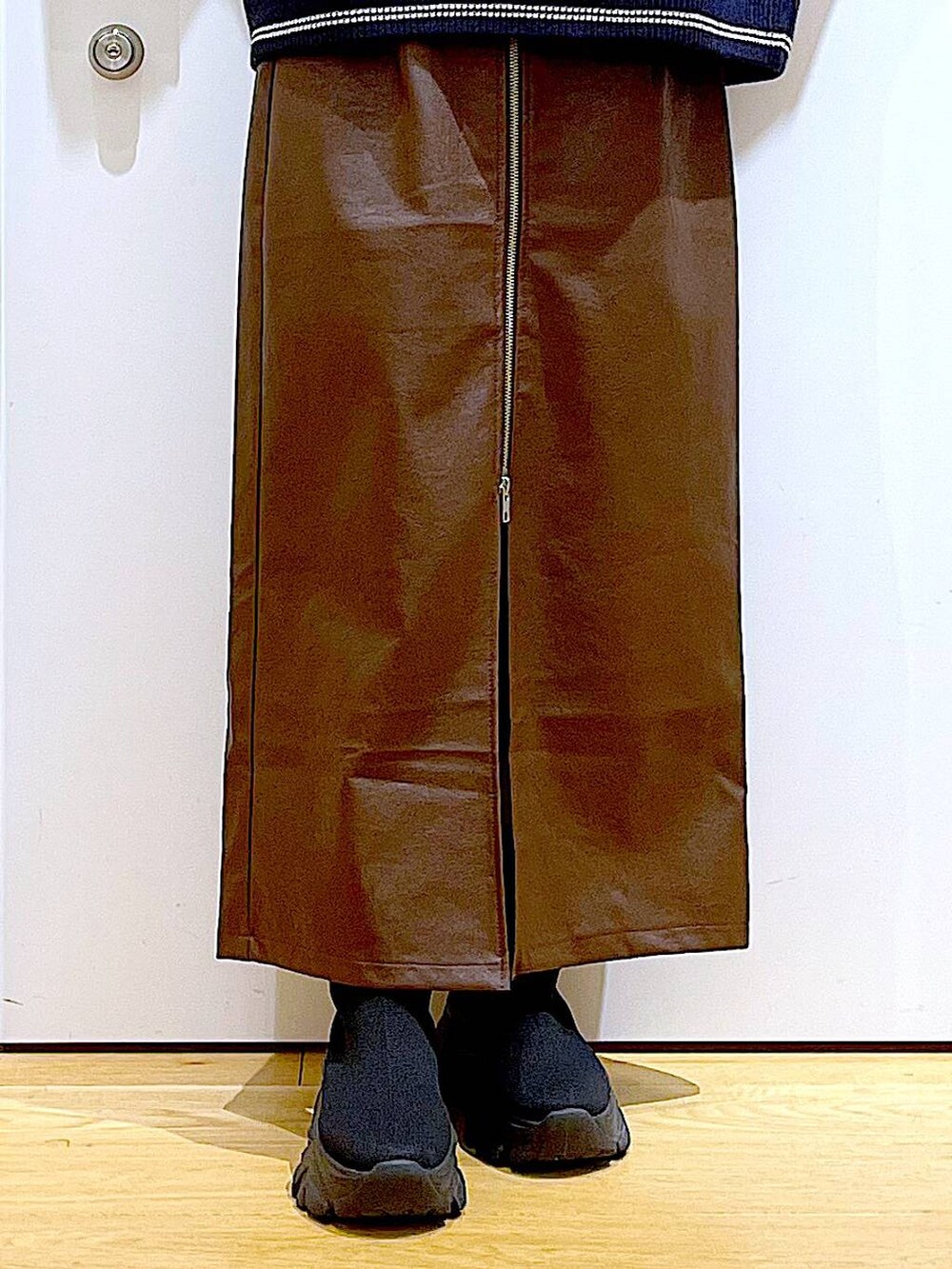 ブラウン系のスカート、ブラック系のブーツ、シルバー系のショルダーバッグを着用したレディースの冬コーディネートの8枚目の写真