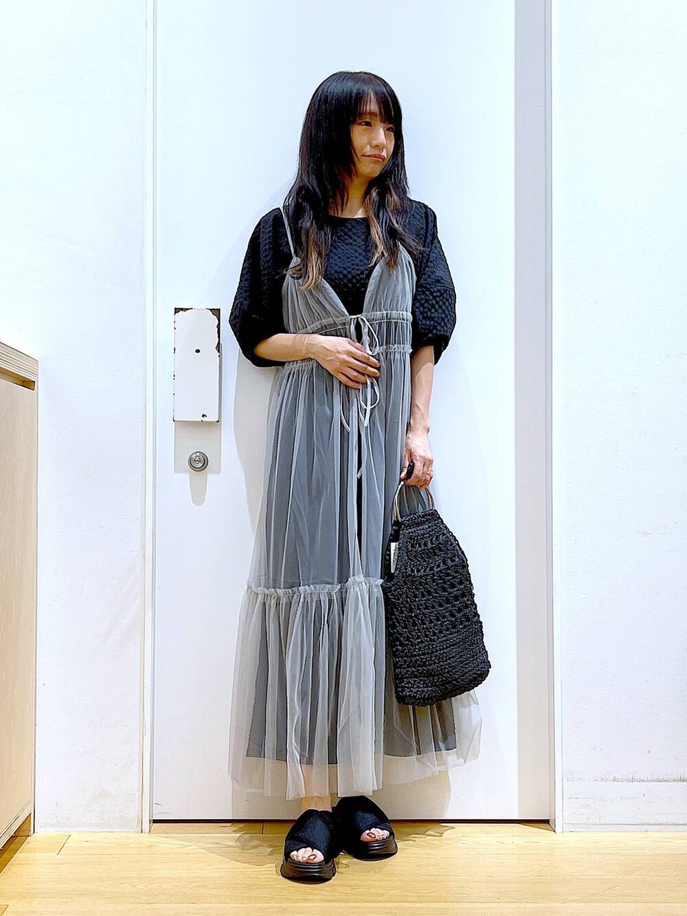 グレー系のワンピース、ブラック系のワンピース、ブラック系のサンダルを着用したレディースの春コーディネートの2枚目の写真