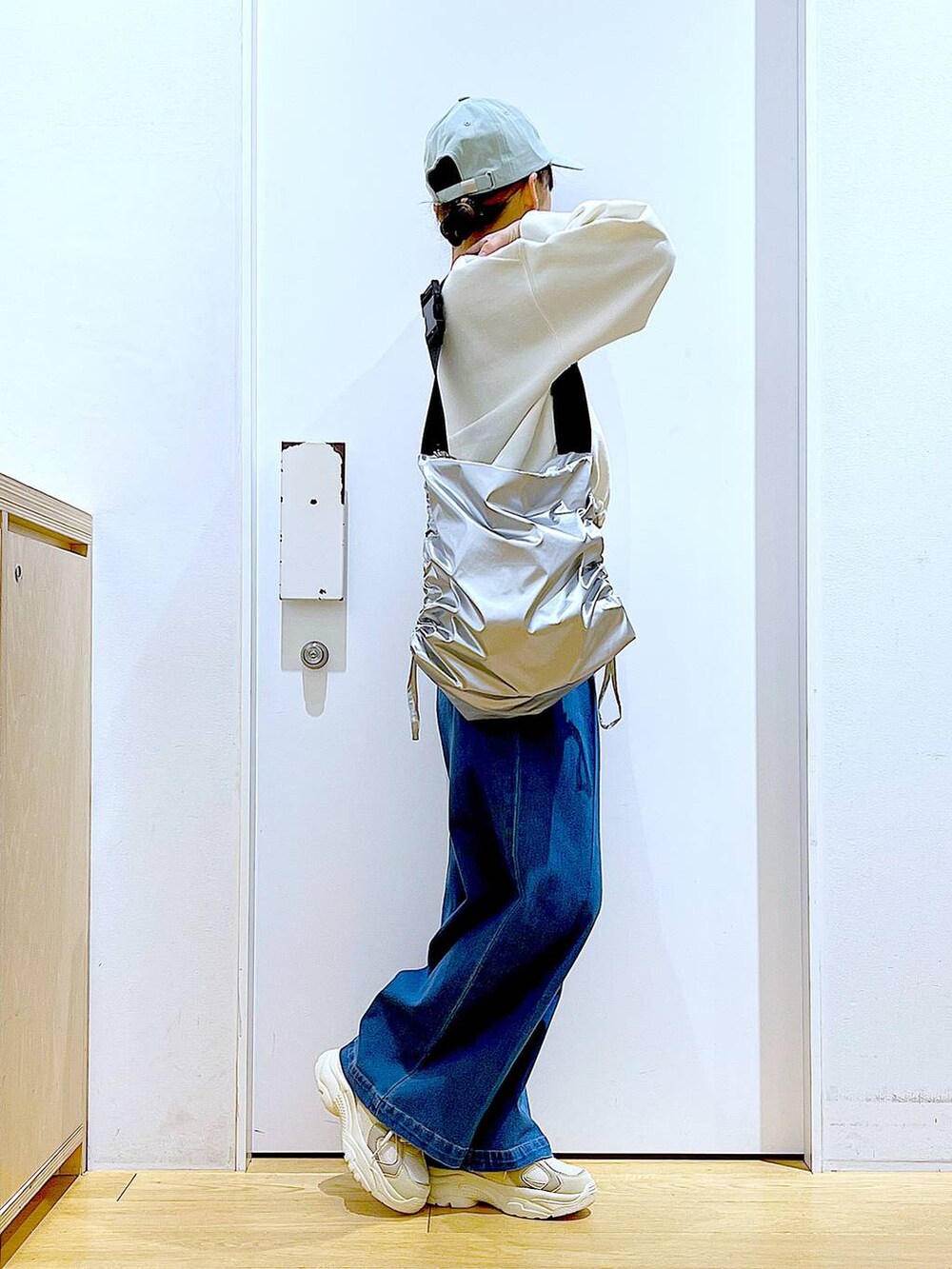 ホワイト系のスウェット、ブルー系のデニムパンツ、ベージュ系のスニーカーを着用したレディースの冬コーディネートの4枚目の写真