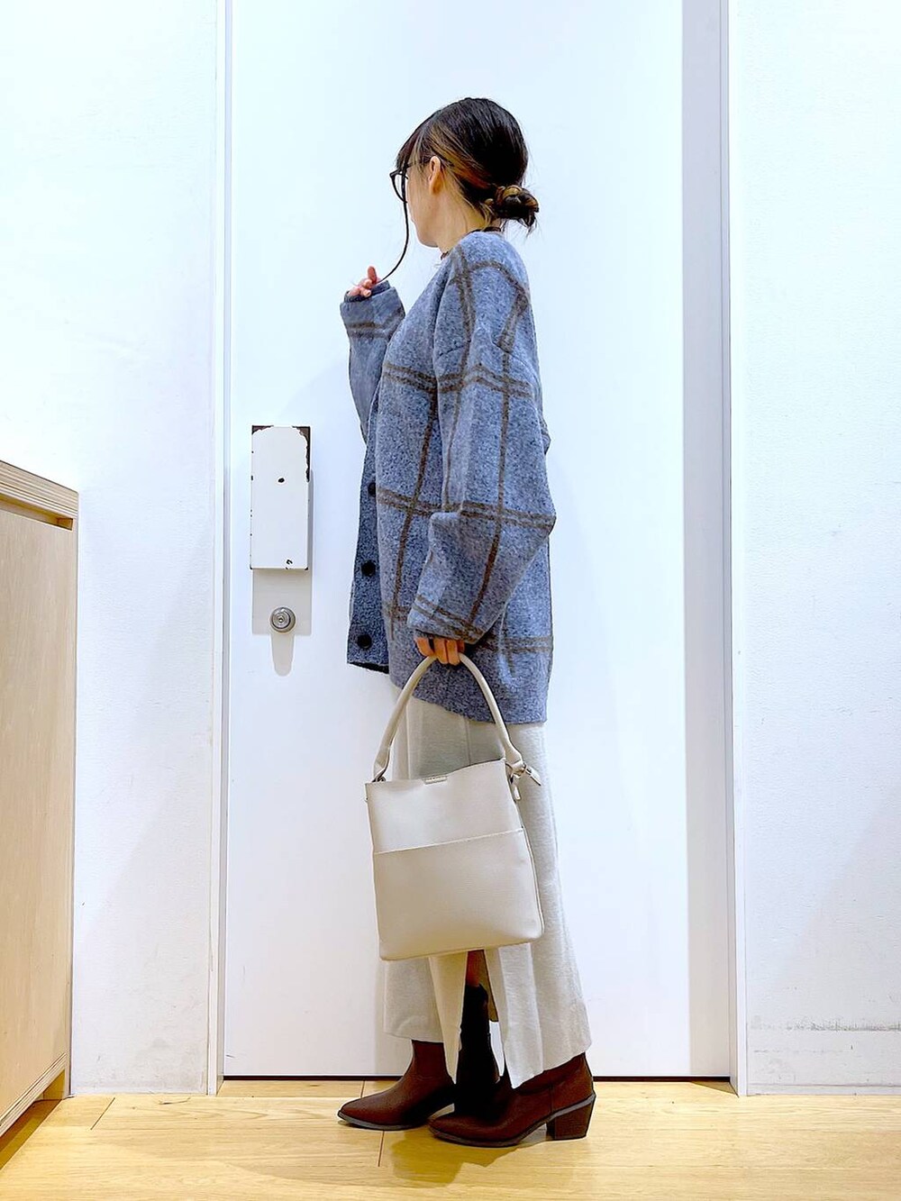 ブルー系のカーディガン/ボレロ、グレー系のショルダーバッグ、グレー系のスカートを着用したレディースの冬コーディネートの3枚目の写真
