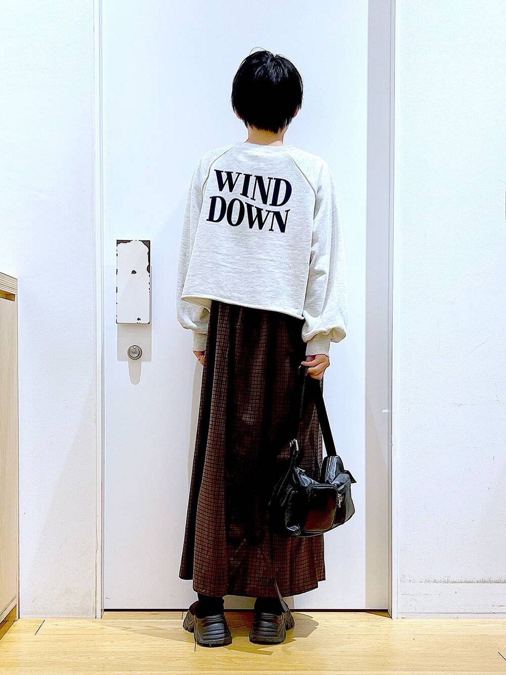 ブラック系のブーツ、ブラック系のショルダーバッグ、ブラウン系のワンピースを着用したレディースの冬コーディネートの5枚目の写真