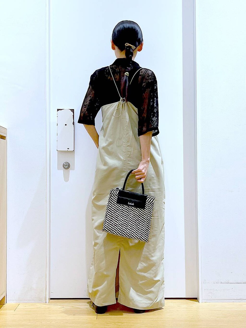 ベージュ系のワンピース、ブラック系のシャツ/ブラウス、ブラック系のパンプスを着用したレディースの春コーディネートの5枚目の写真