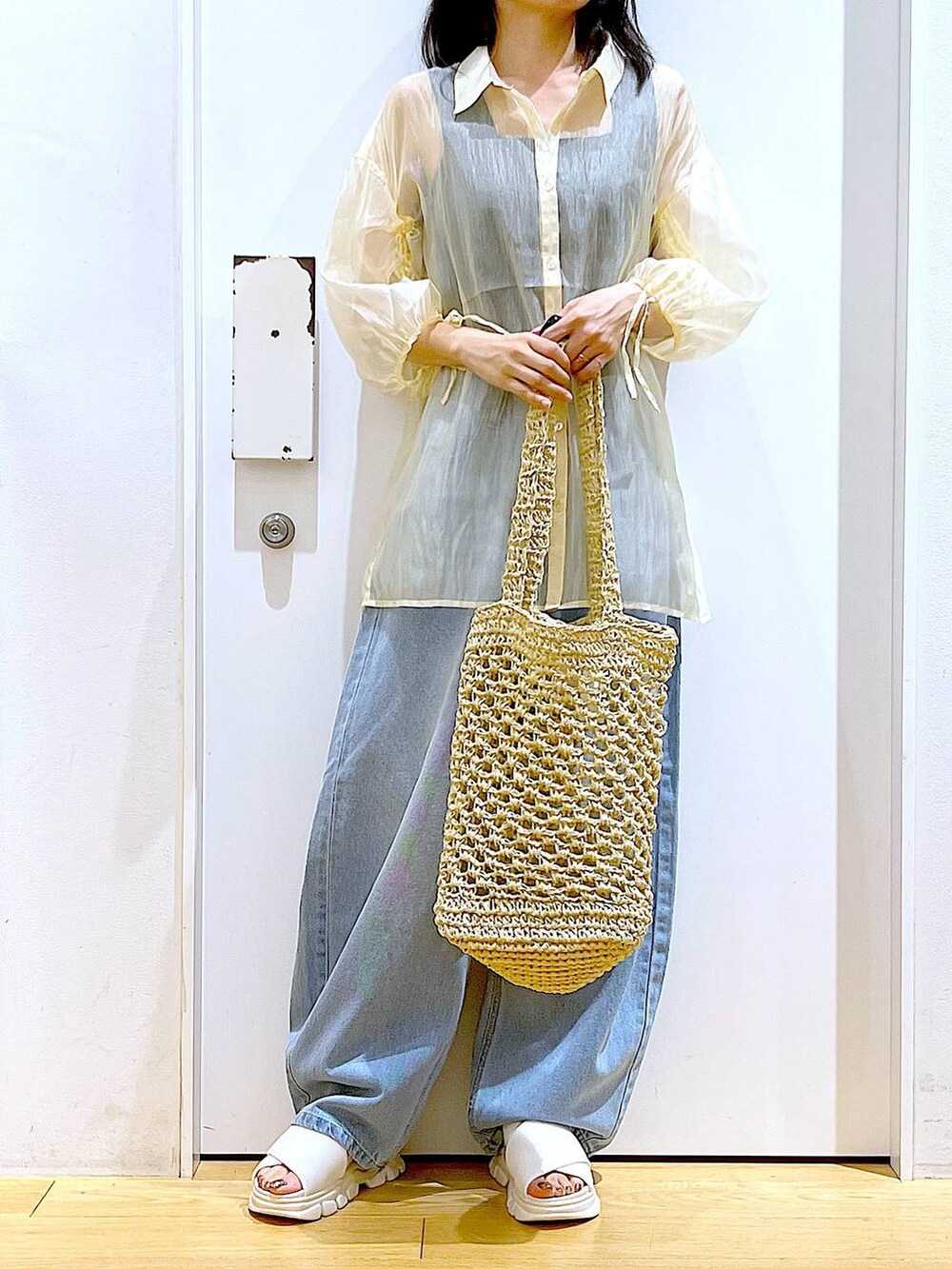 ホワイト系のサンダル、ホワイト系のトートバッグ、ブルー系のデニムパンツを着用したレディースの夏コーディネートの6枚目の写真