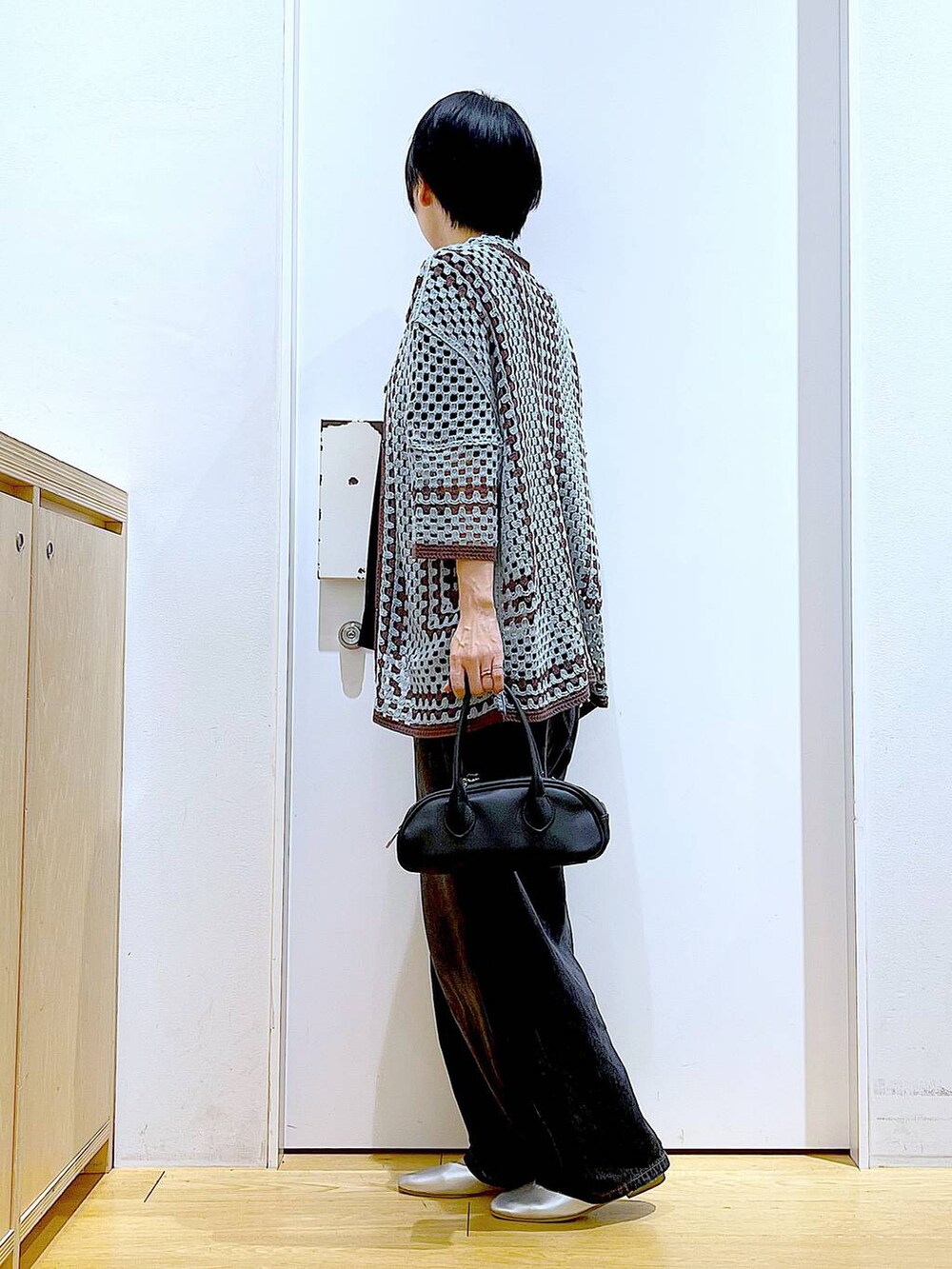 ブラック系のデニムパンツ、ブラック系のボストンバッグ、シルバー系のパンプスを着用したレディースの夏コーディネートの3枚目の写真