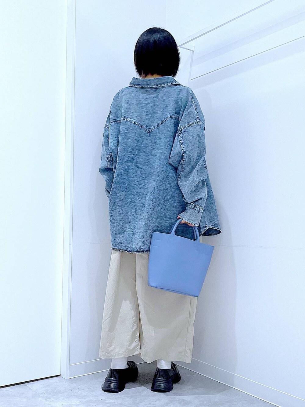 ブルー系のシャツ/ブラウス、ブルー系のショルダーバッグ、ブラック系のローファーを着用したレディースの秋コーディネートの5枚目の写真