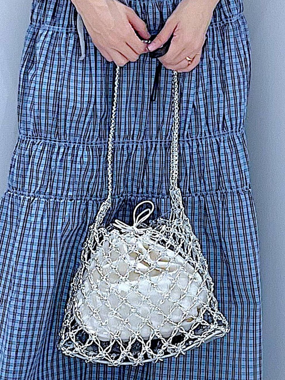 シルバー系のかごバッグ、シルバー系のサンダル、ブルー系のスカートを着用したレディースの夏コーディネートの9枚目の写真