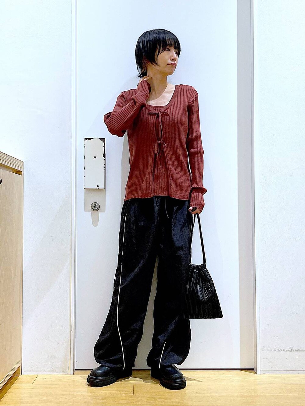 ブラック系のショルダーバッグ、ブラック系のブーツ、ブラウン系のカーディガン/ボレロを着用したレディースの秋コーディネートの2枚目の写真