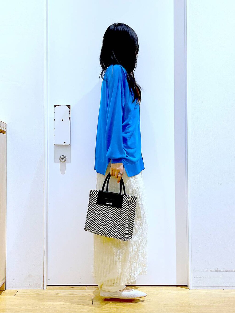 ホワイト系のその他パンツ、ブルー系のカーディガン/ボレロ、ホワイト系のパンプスを着用したレディースの春コーディネートの4枚目の写真