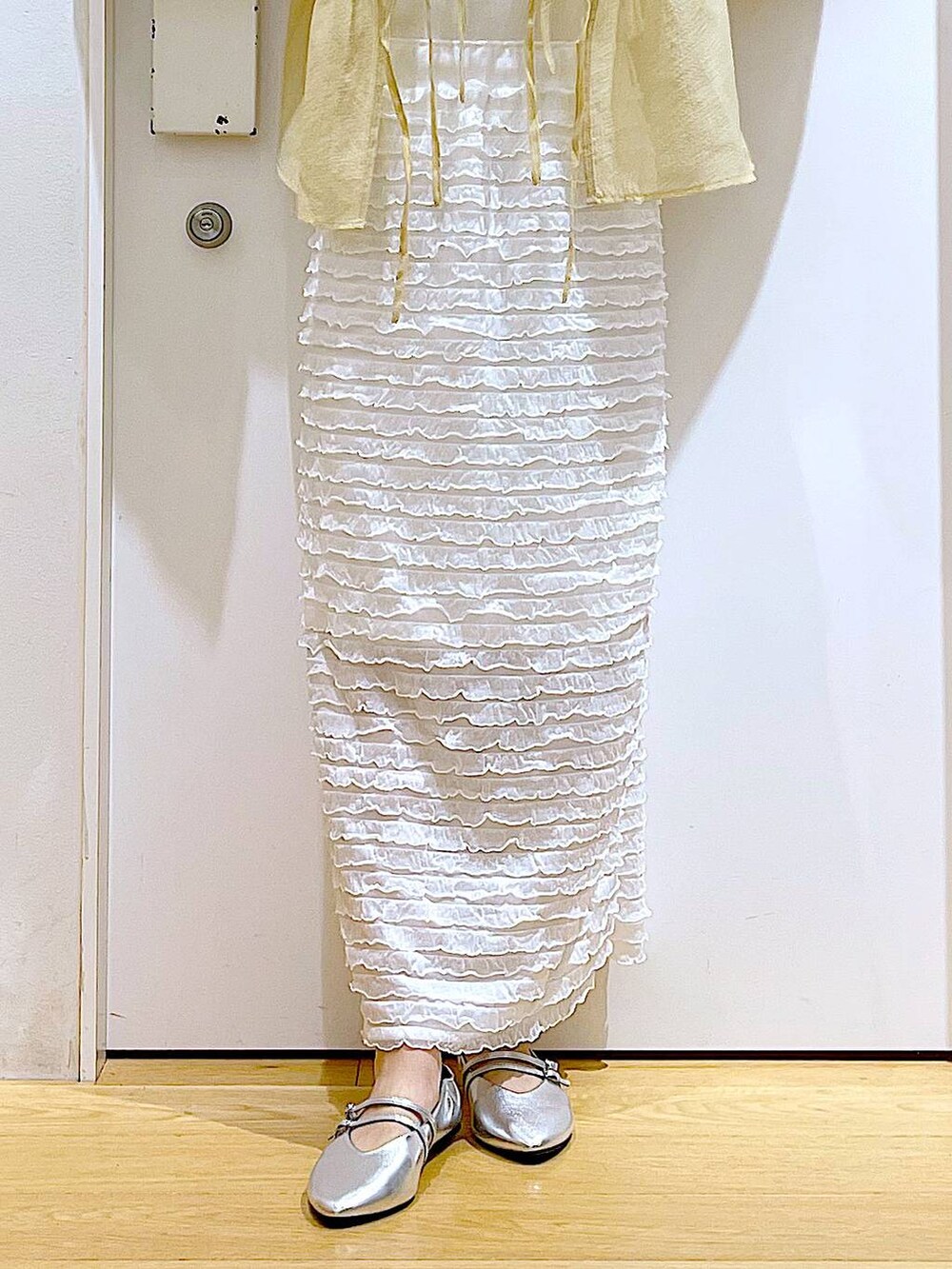 ホワイト系のベスト、ホワイト系のショルダーバッグ、ホワイト系のスカートを着用したレディースの秋コーディネートの8枚目の写真