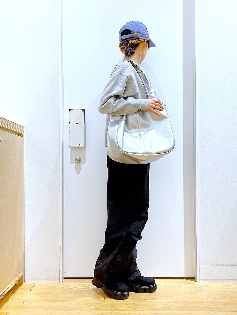 シルバー系のトートバッグ、ブラック系のブーツ、ブラック系のその他パンツを着用したレディースの冬コーディネートの4枚目の写真